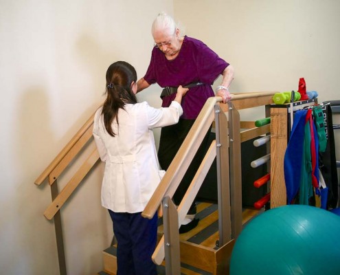 Physical Therapist works with woman on stairs